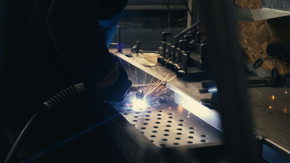 A welder at work on a steel plate, sparks flying: one of the trades with free job training programs